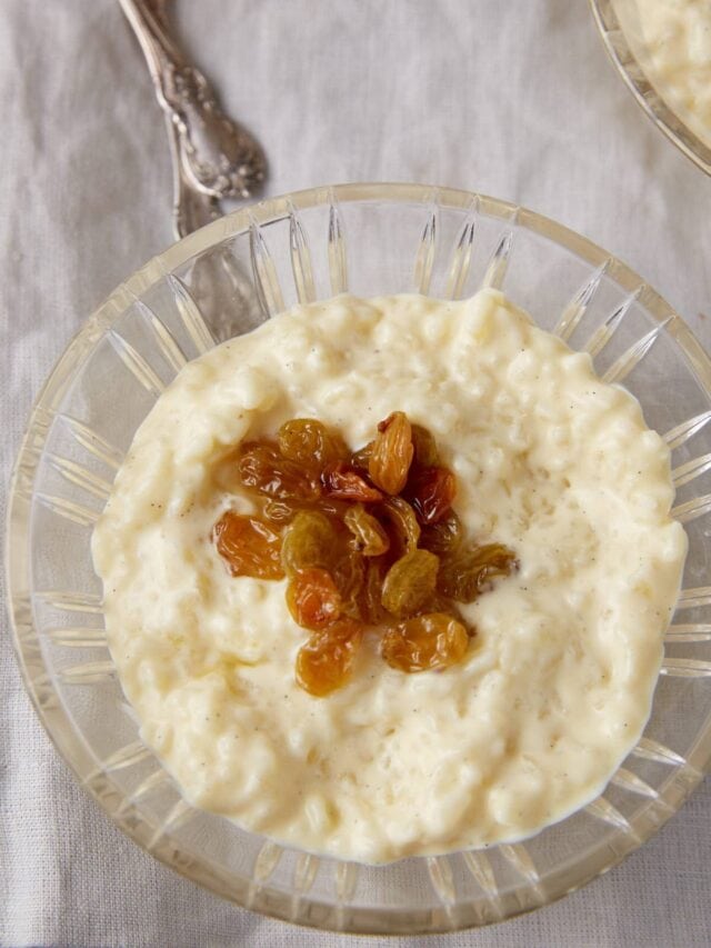 A single bowl of rice pudding tooped with raisins.