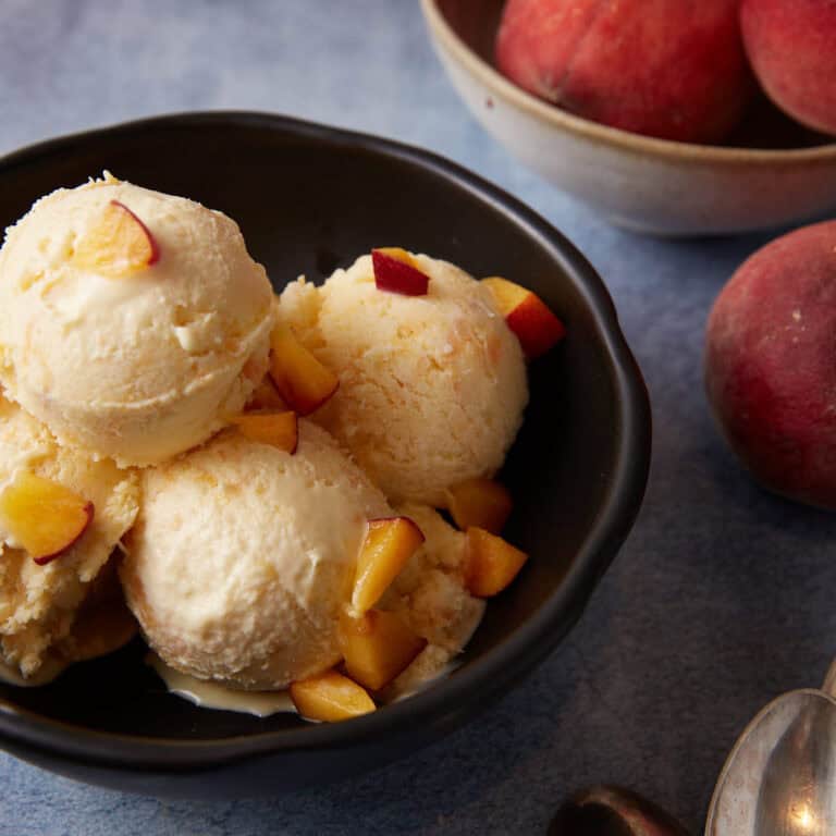 A bowl of peach ice cream scoops.