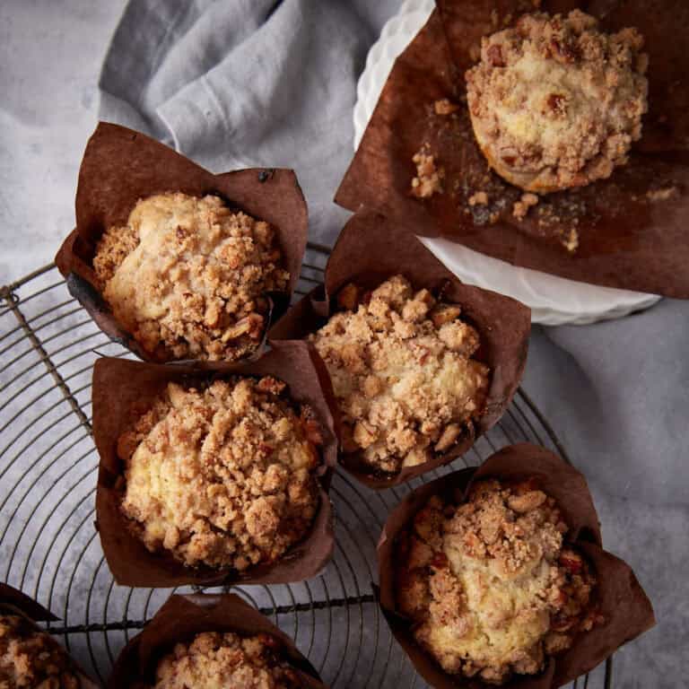 A batch of rhubarb muffins on a cooling rack.