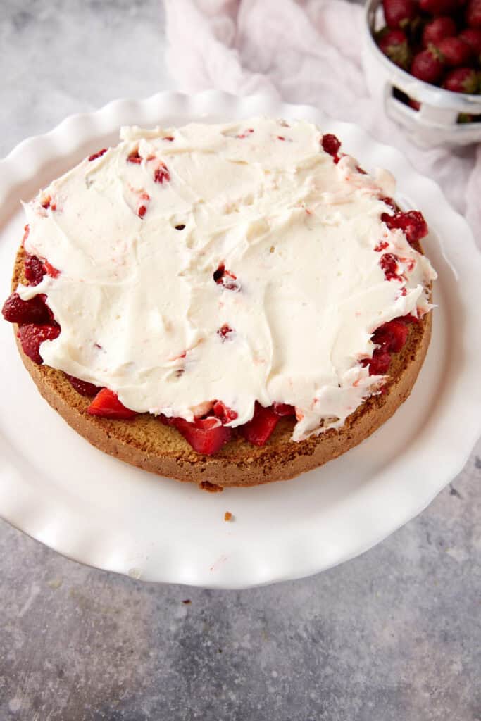 Frosting on top of a strawberry layer.