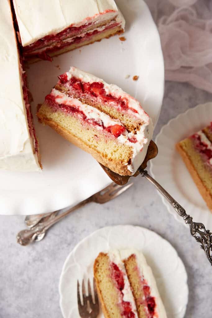 A layer of strawberry shortcake being put on a plate.