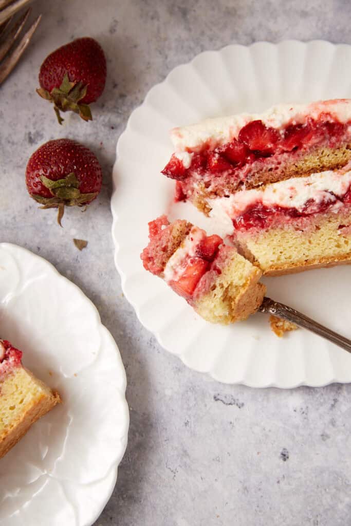 A bite of strawberry cake on a fork.
