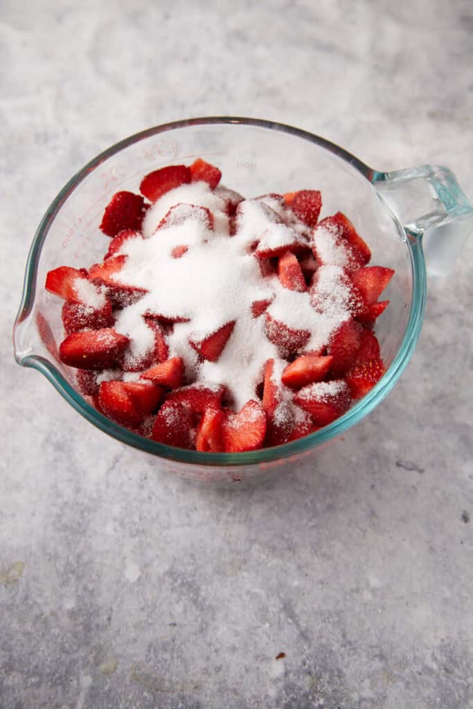Strawberries covered with sugar in a bowl.