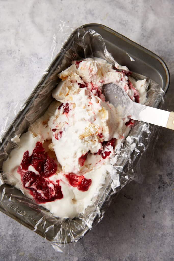 Mixing the cream with the strawberry mixture.