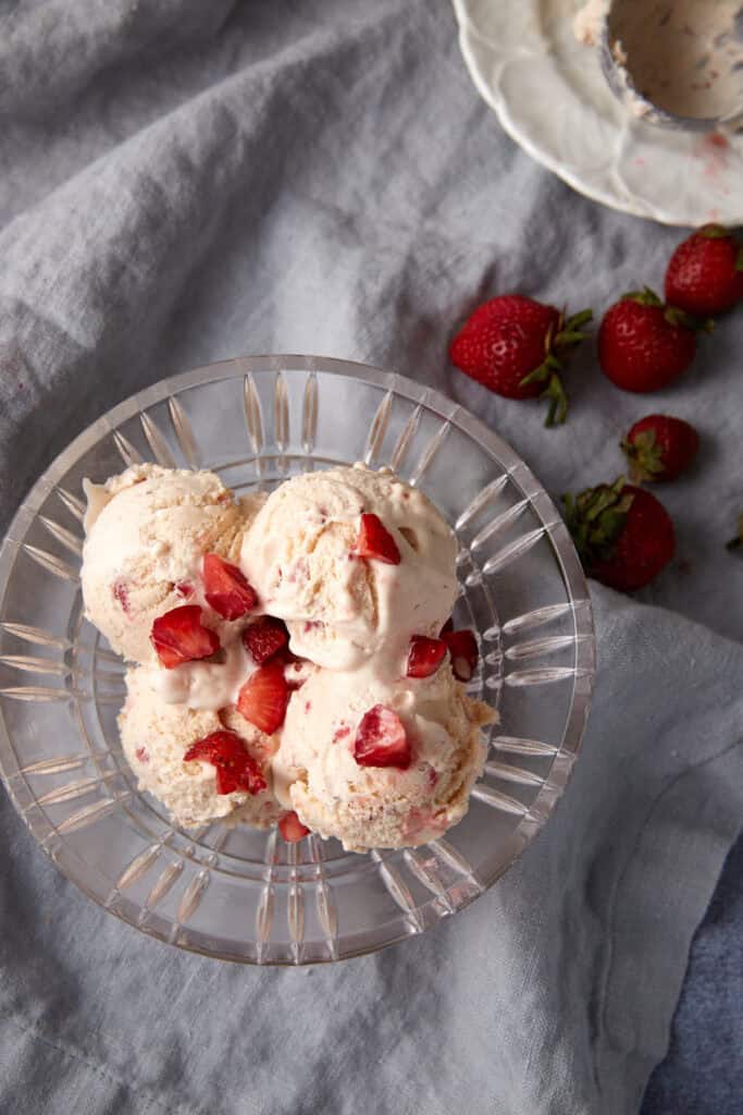 Four scoops of strawberry ice cream in a bowl.