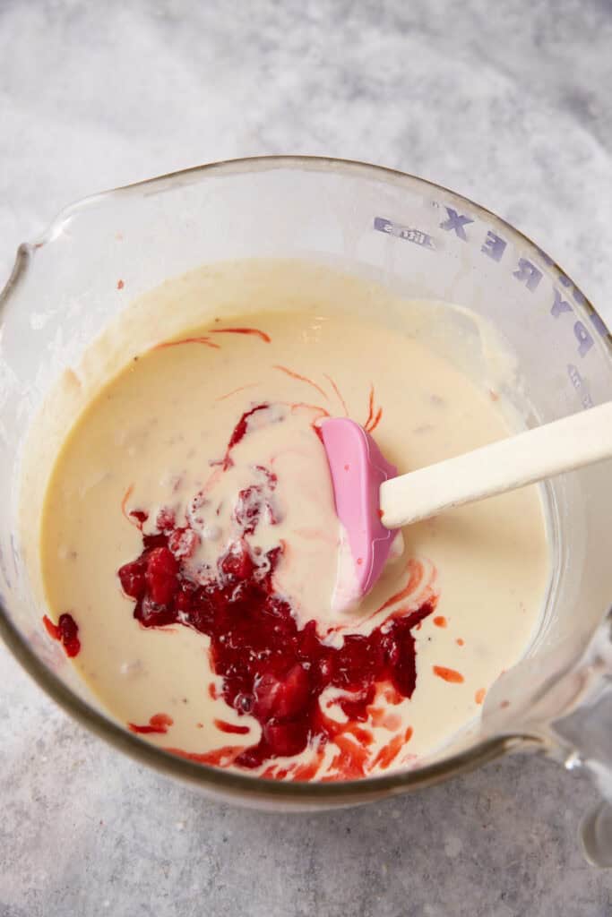 Strawberries being added to the cooled custard.