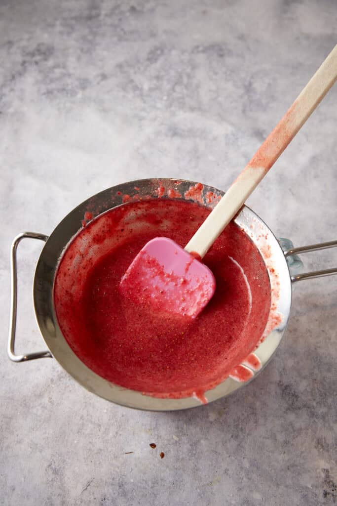 A spatula pressing down the strawberry mixture.