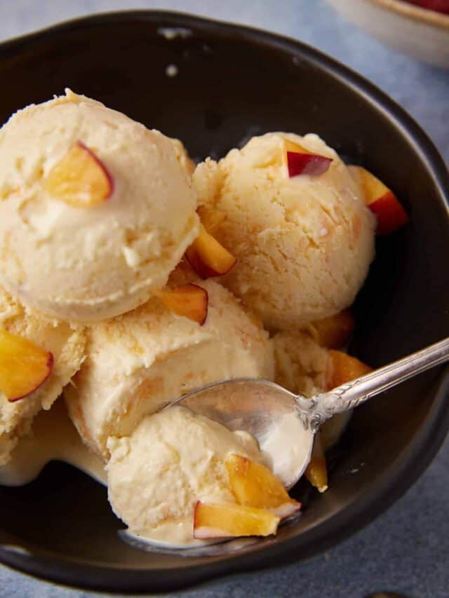A spoon full of peach ice cream.