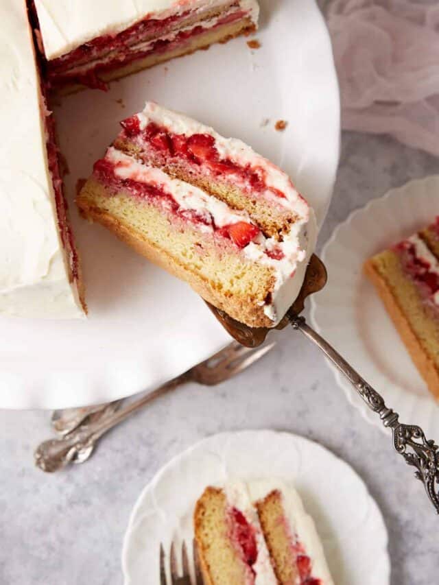 A layer of strawberry shortcake being put on a plate.