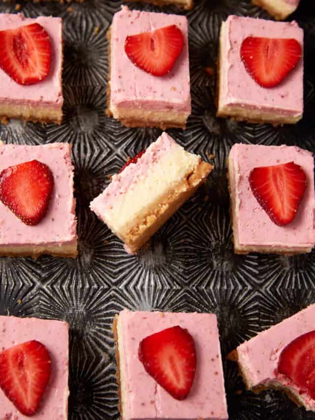 A tray of strawberry cheesecake bars with one turned on its side.