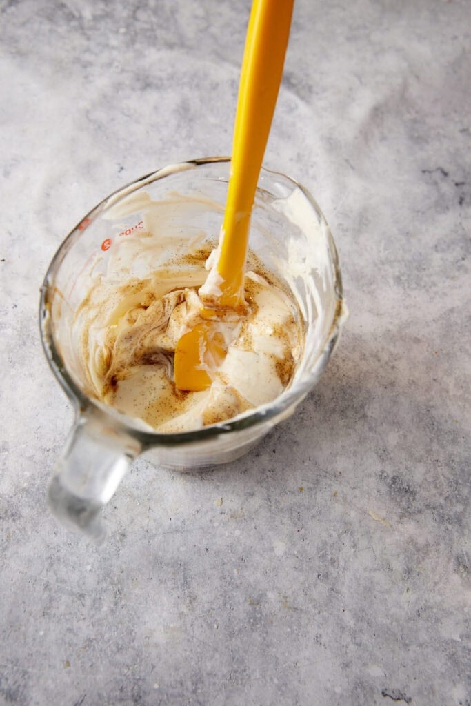 Creme fraiche with vanilla in a measuring cup.
