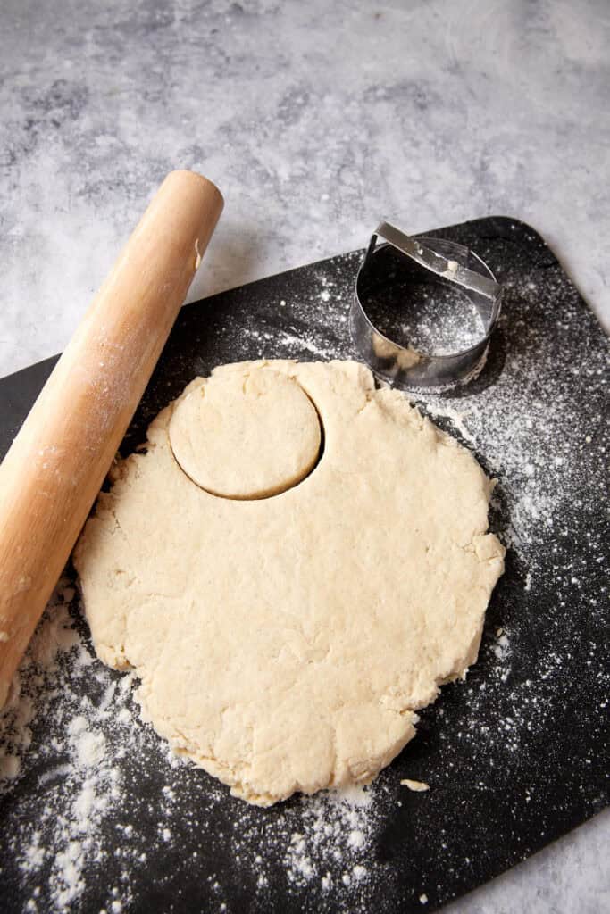 Biscuits being cut on a cutting board.