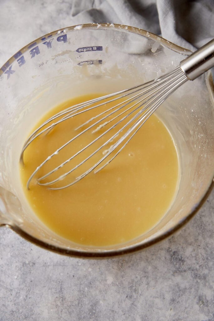 Vanilla sauce in a bowl with a whisk.