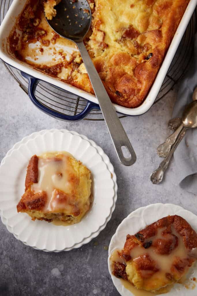 Bread pudding servings on white plates.