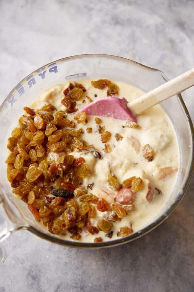A bowl of bread, custard and raisins.
