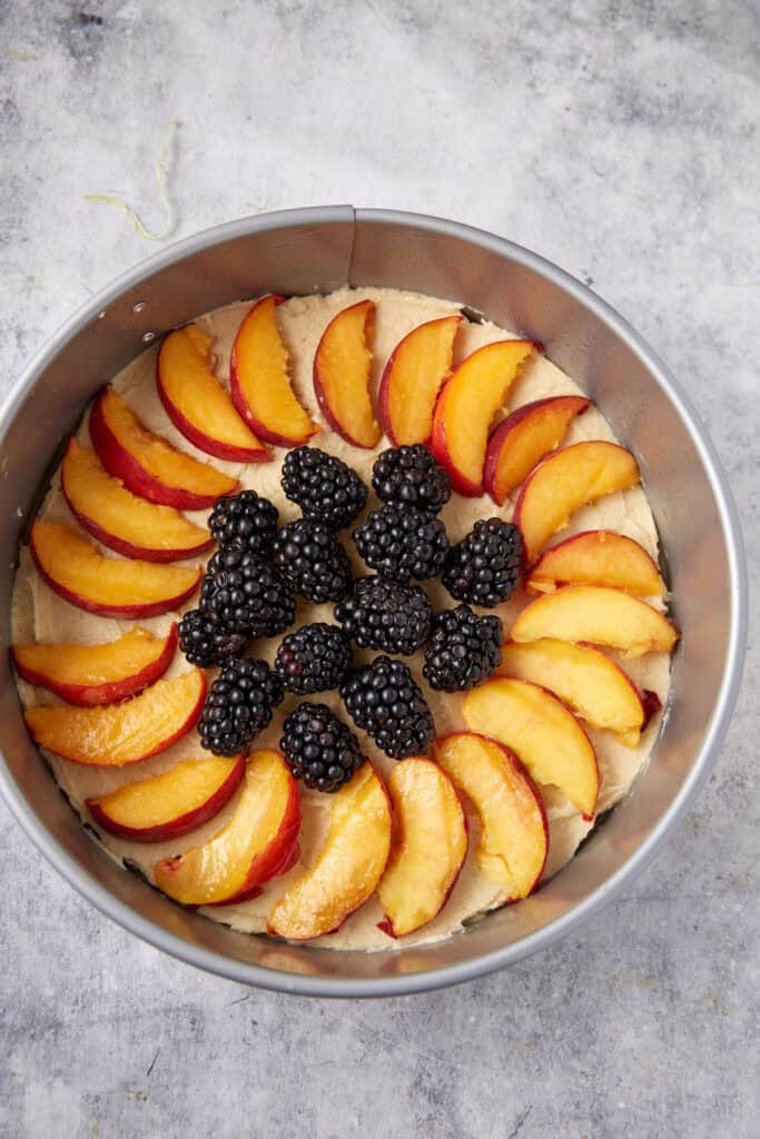 Peaches and blackberries on top of cake batter.