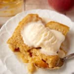 A serving of peach cobbler cake on a white plate.