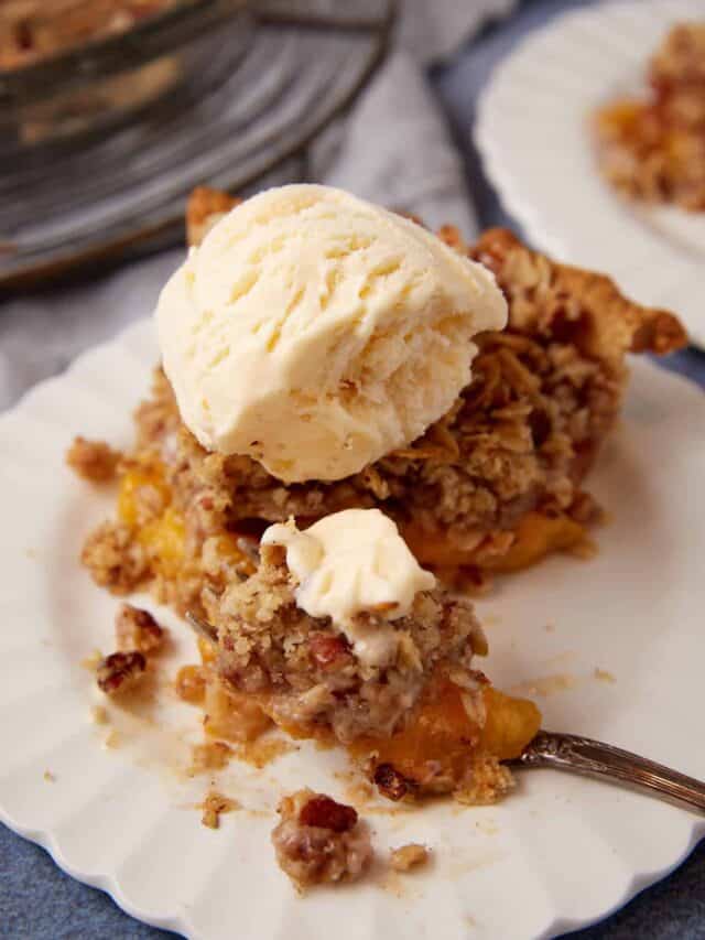 A bite of peach crumble pie with ice cream.
