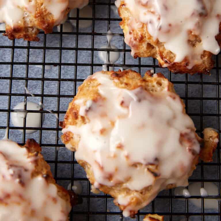 A glazed baked apple fritter on a wire rack.
