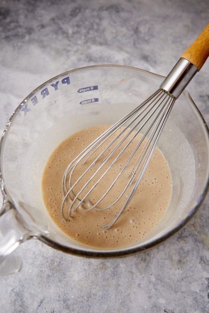 The cake batter in a bowl with a whisk.