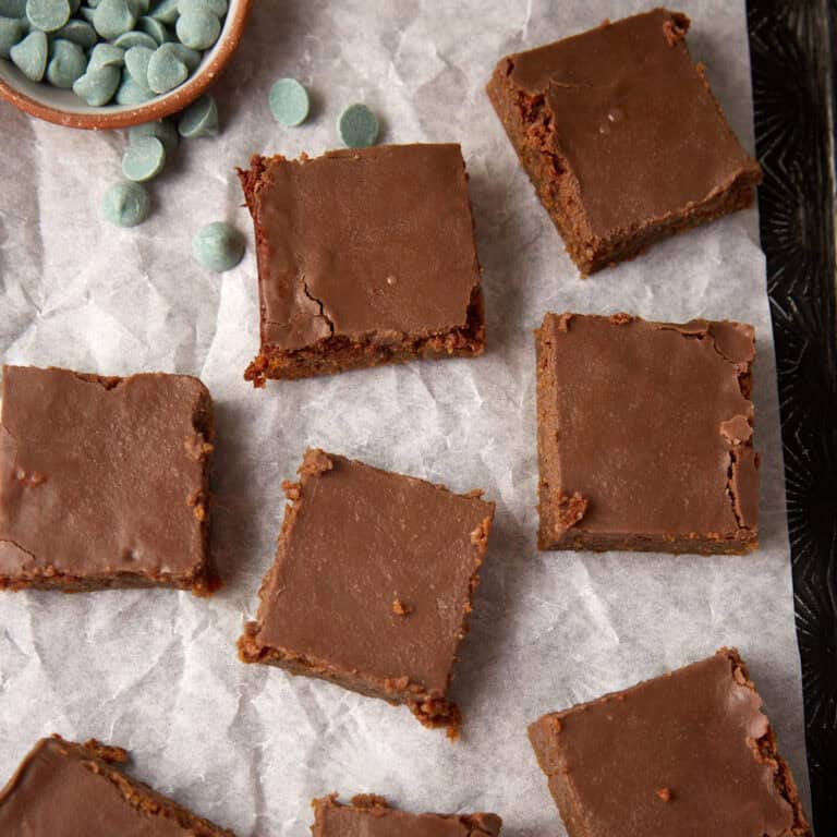 Mint brownies next to a bowl of mint chips.
