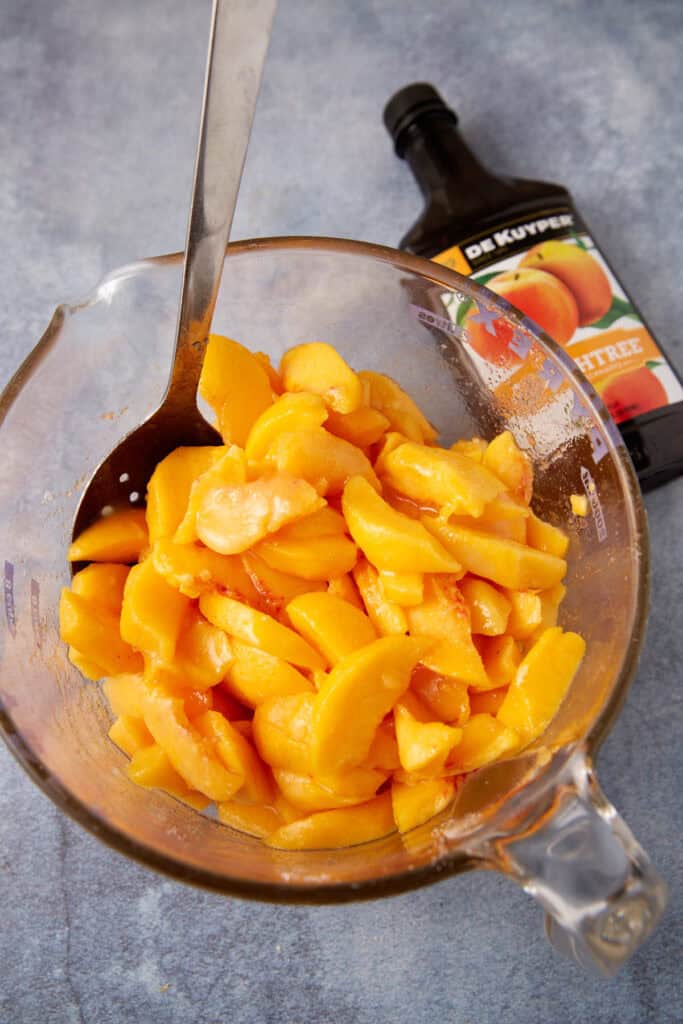 Peaches in a bowl with peach schnapps.