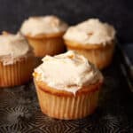 Frosted peach cupcakes on a platter.