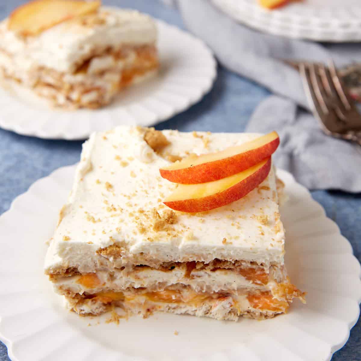 Two servings of peach icebox cake on white plates.