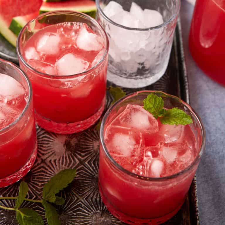 A tray with glasses of watermelon lemonade.