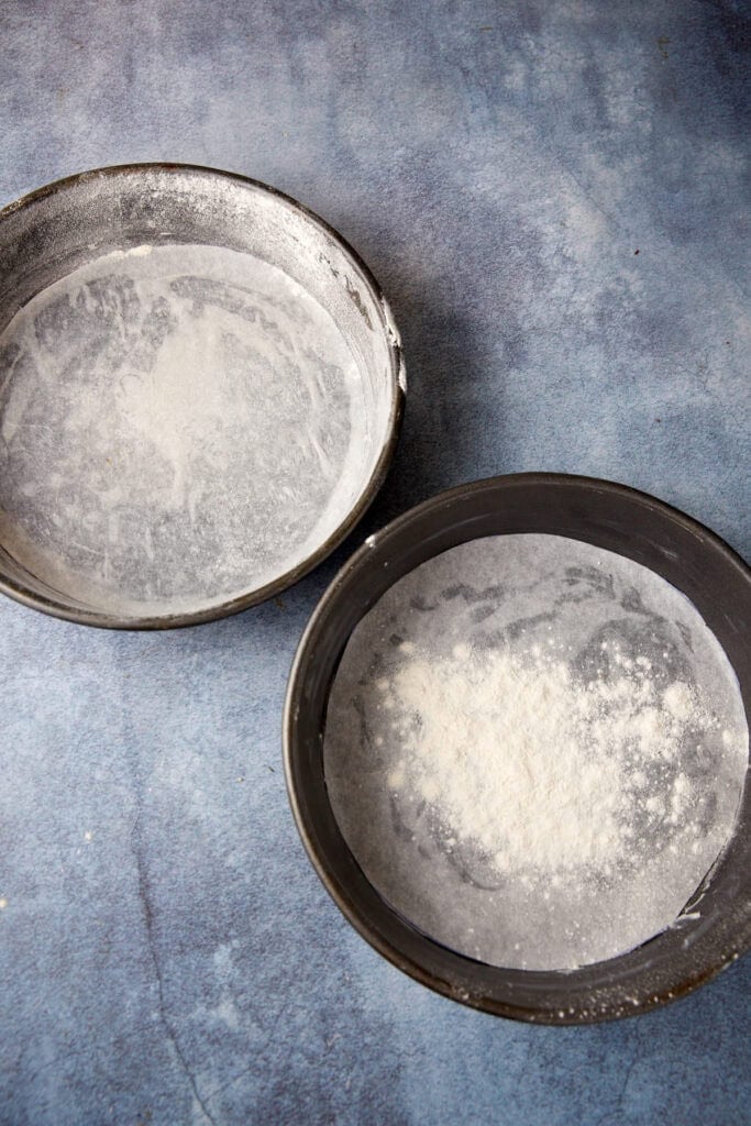 Two cake pans with butter and flour.
