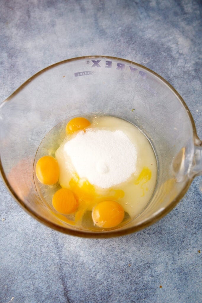 Eggs and sugar in a mixing bowl.