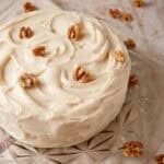 Brown butter frosting on a layer cake topped with walnuts.