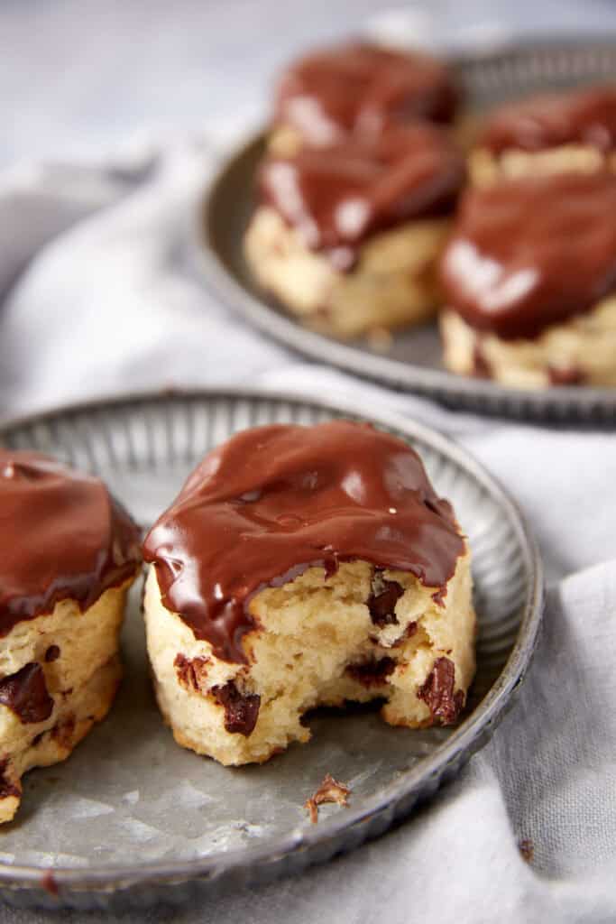 A chocolate dipped biscuit with a bite taken out.
