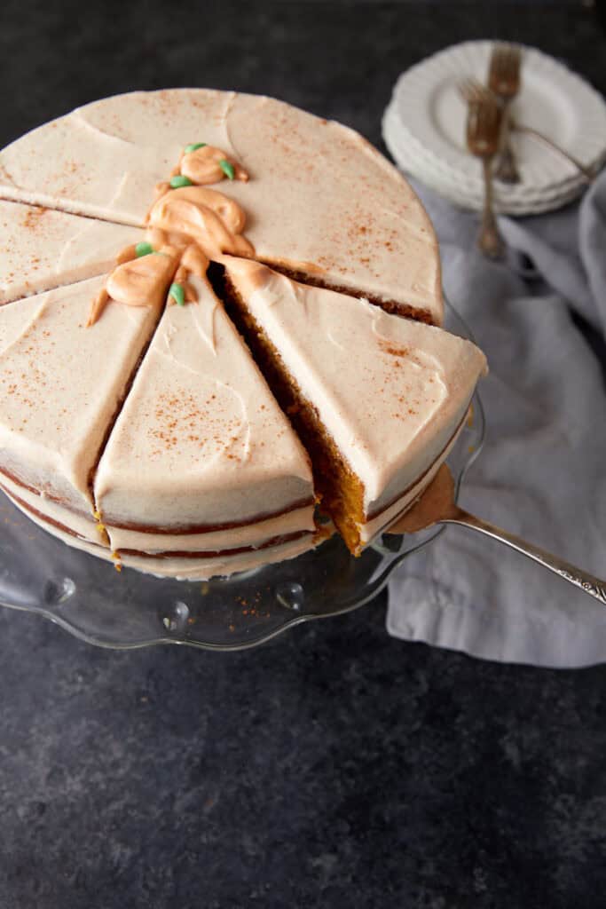A pumpkin layer cake with a slice being removed. 