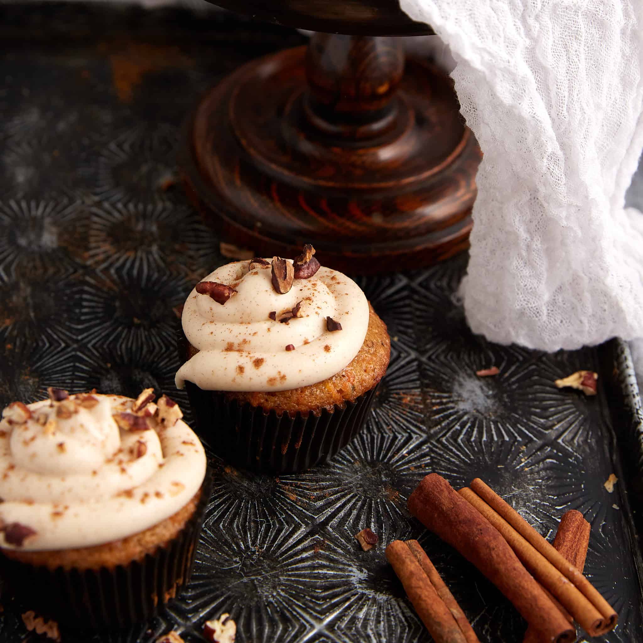 Two cupcakes topped with brown sugar cream cheese frosting.