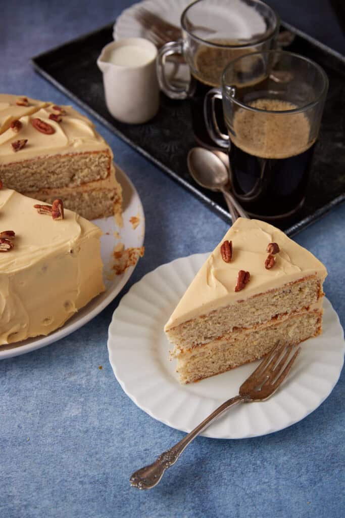 Caramel cake next to cups of coffee.