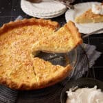 A slice of coconut custard pie being removed form a pie plate.