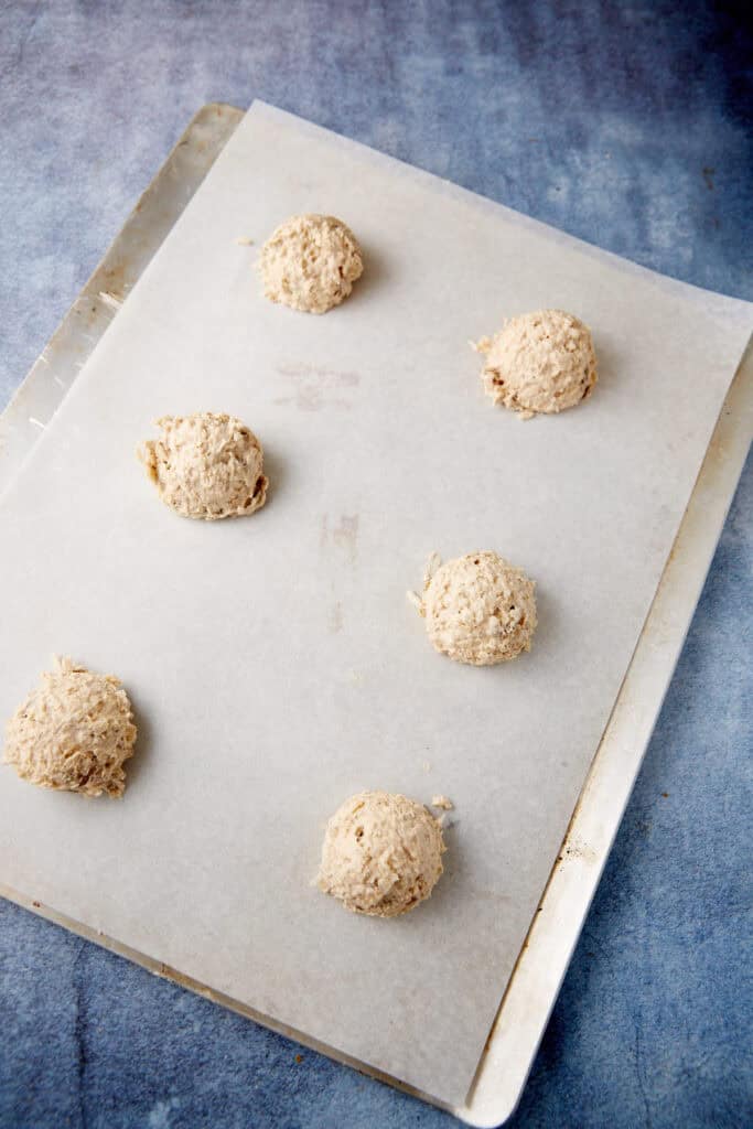 balls of coconut oatmeal cookie dough on a baking sheet.