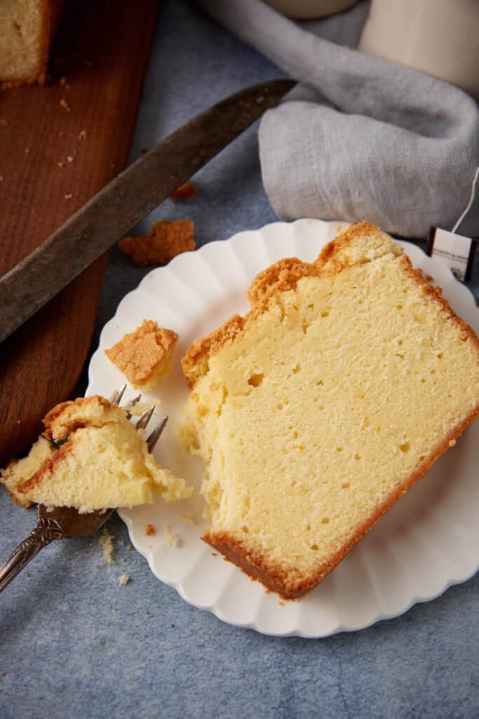 A slice of cream cheeses pound cake with a bite taken out. 
