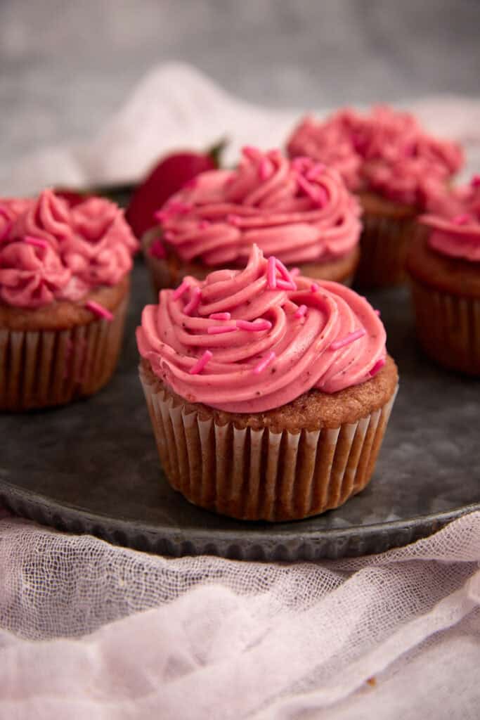 strawberry cream cheese frosting swirled on a cupcake.