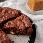 A slice of chocolate bread pudding being removed from a pan.