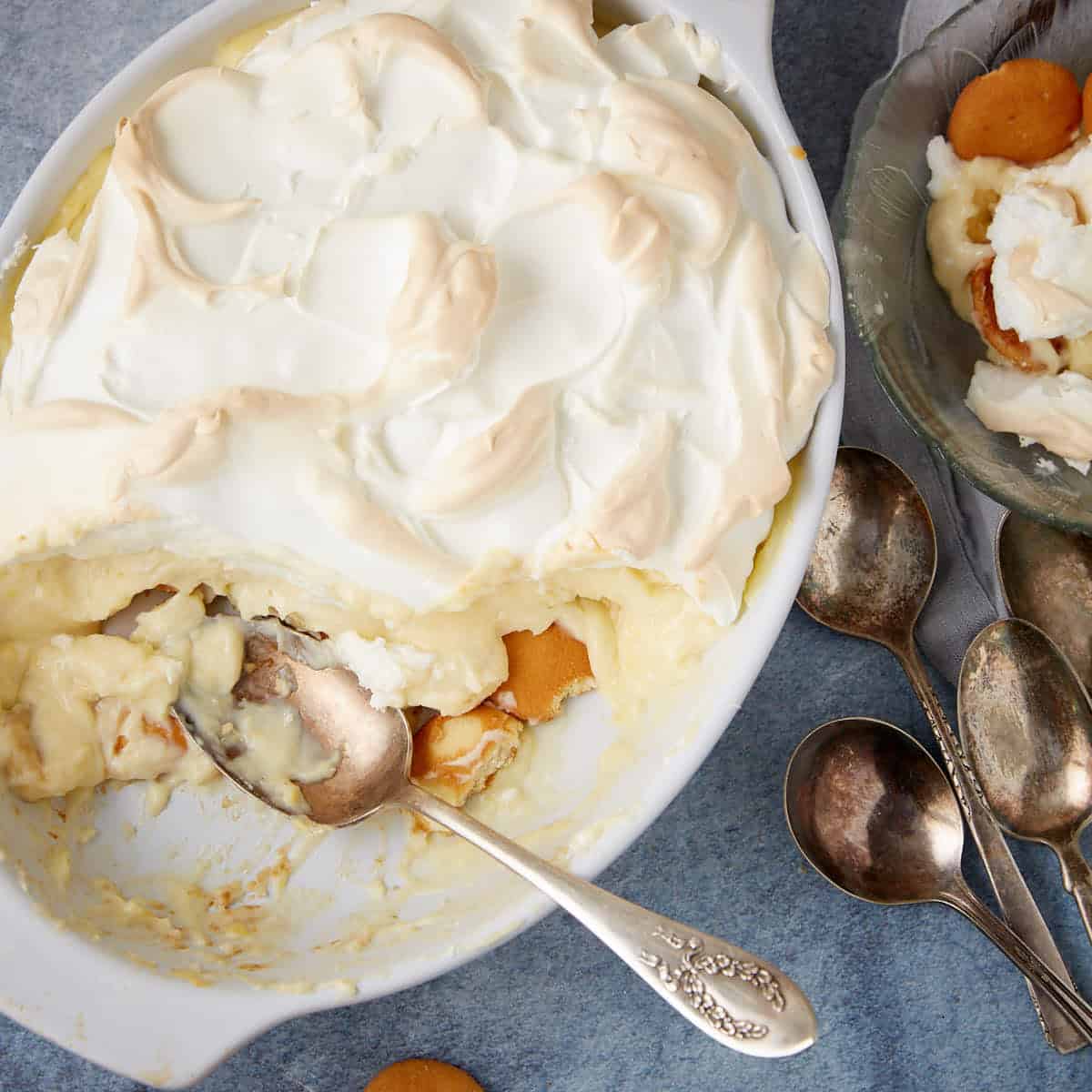 A baking dish of banana pudding with a portion removed.