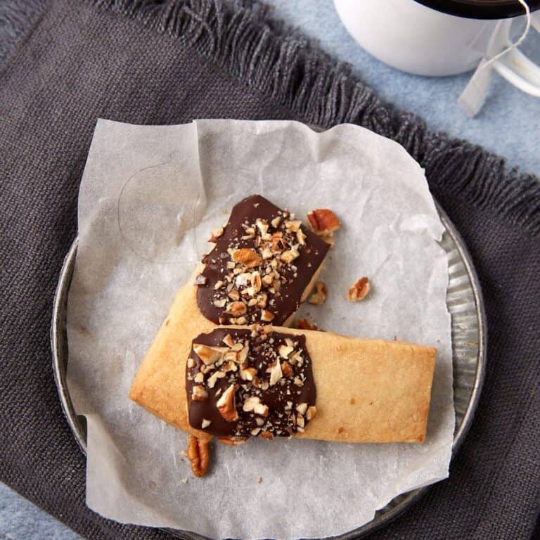 A dessert plate with two chocolate dipped shortbread cookies