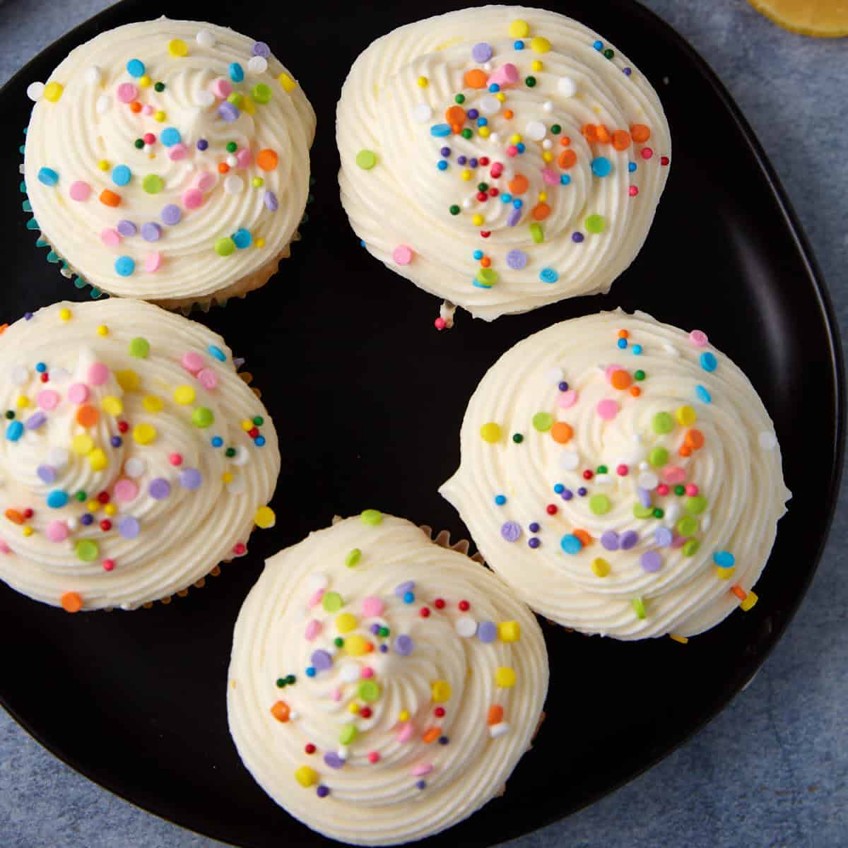 Cupcakes topped with lemon cream cheese frosting.