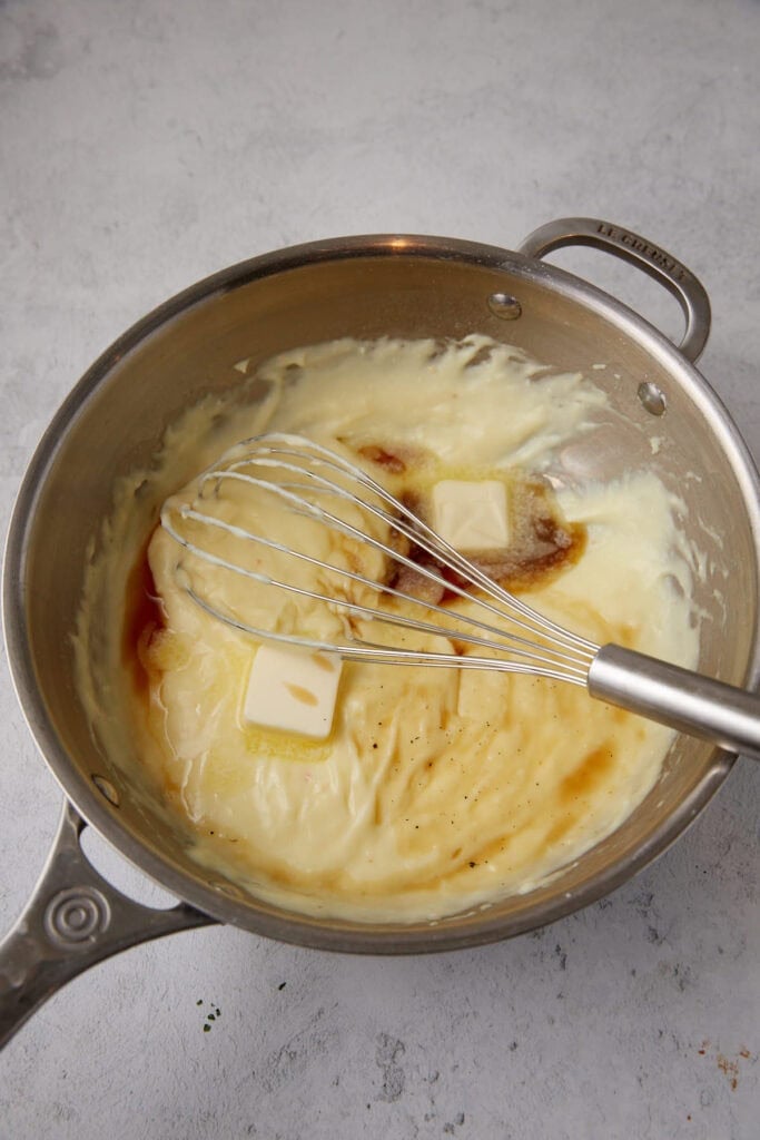 saucepan with custard and butter and vanilla on top.