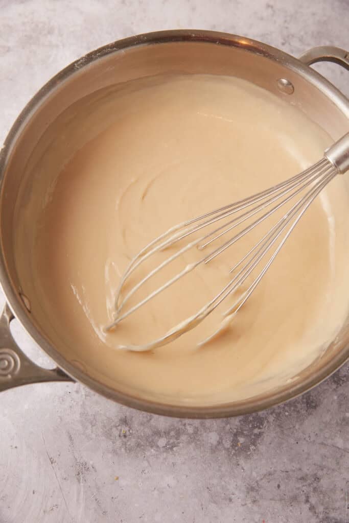 brown sugar custard in a saucepan with a whisk.