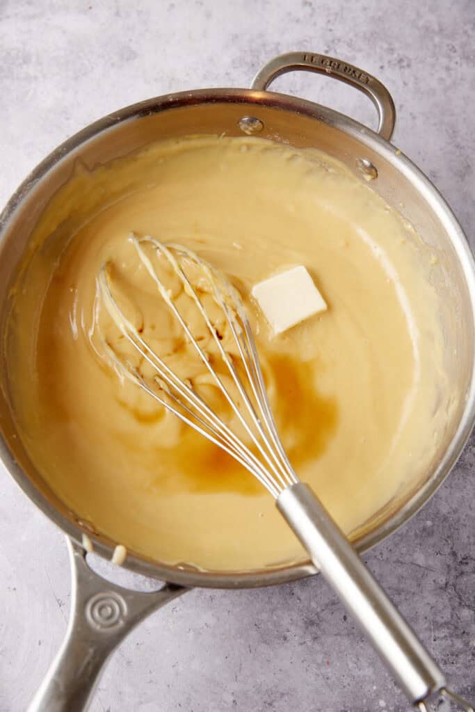 butter and vanilla added to the brown sugar custard in a saucepan with a whisk.