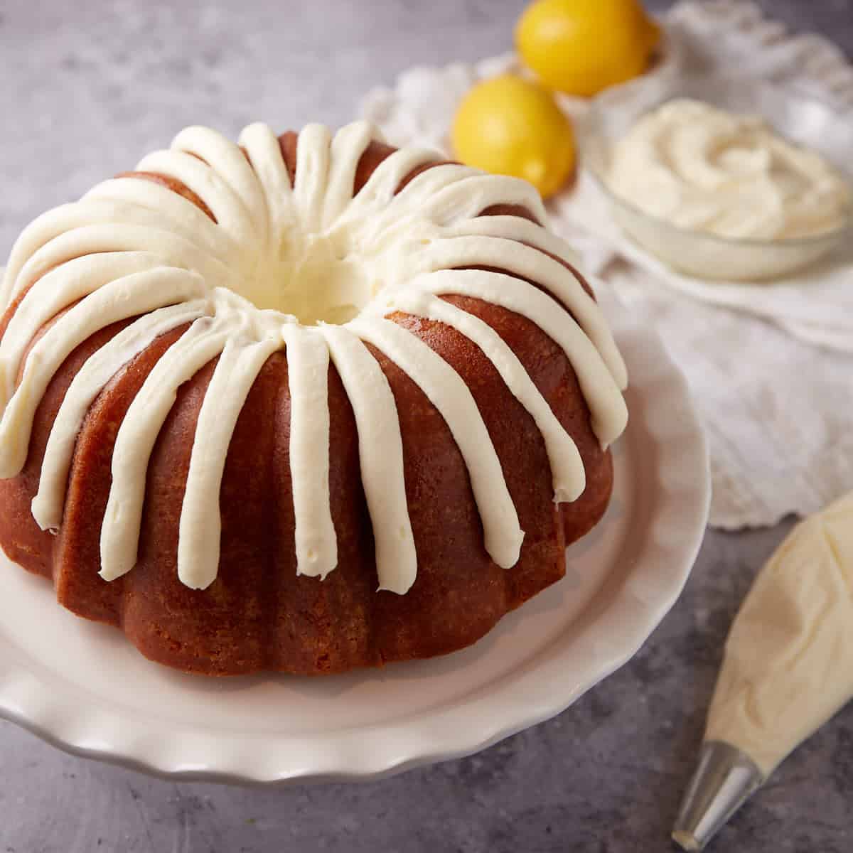 lemon bundt cake on a white cake stand.