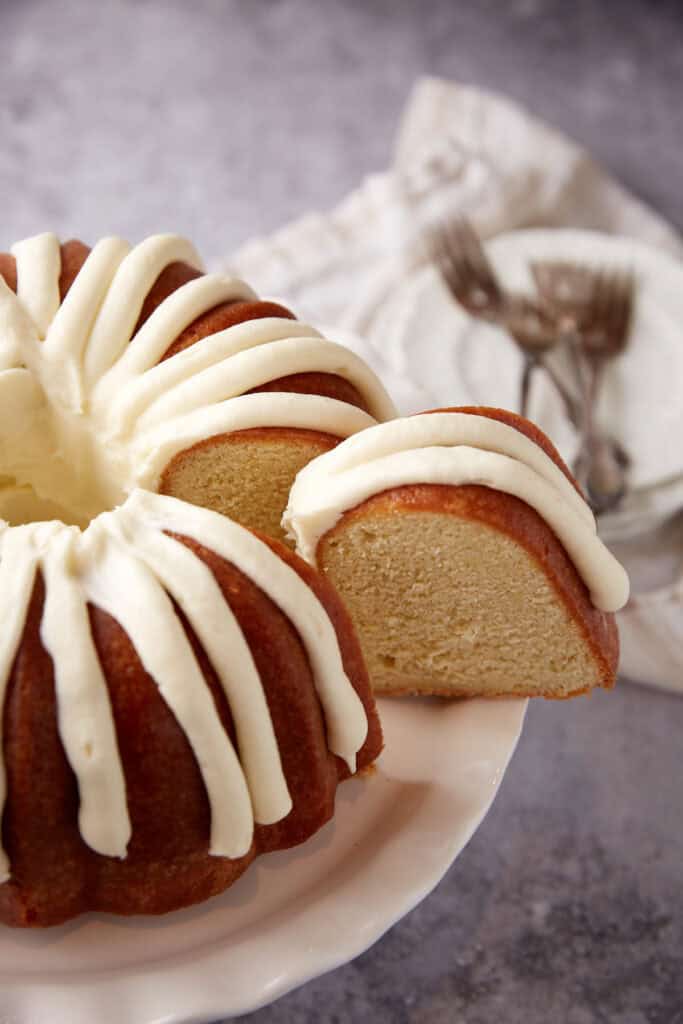 slice of lemon bundt cake coming out of the cake. 