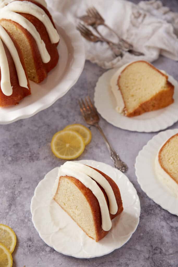 three slices of lemon bundt cake on white dessert plates.